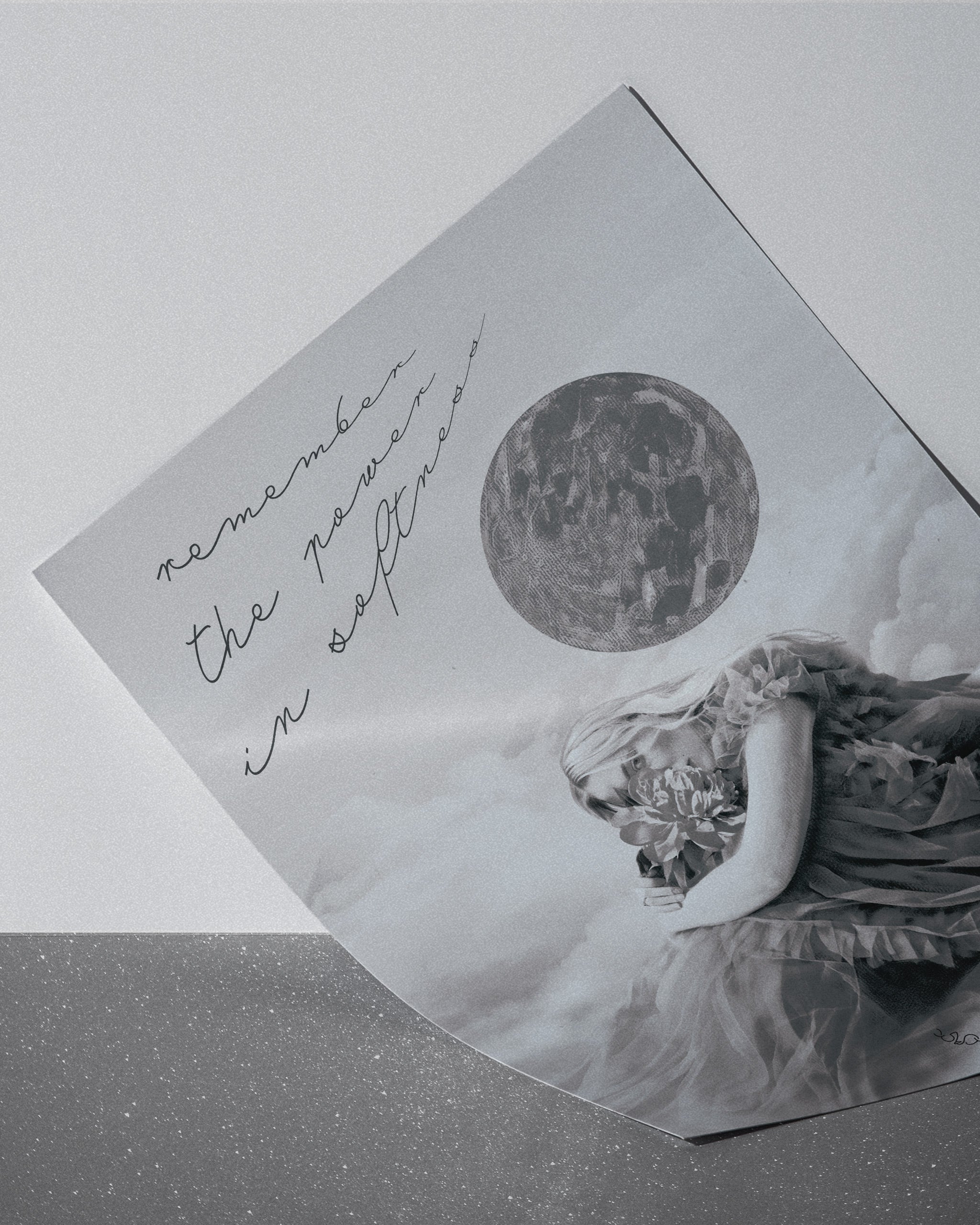 monochromatic poster of a light changer, a woman in a dress and a moon image, text 'remember the power in softness' on a light gray background.