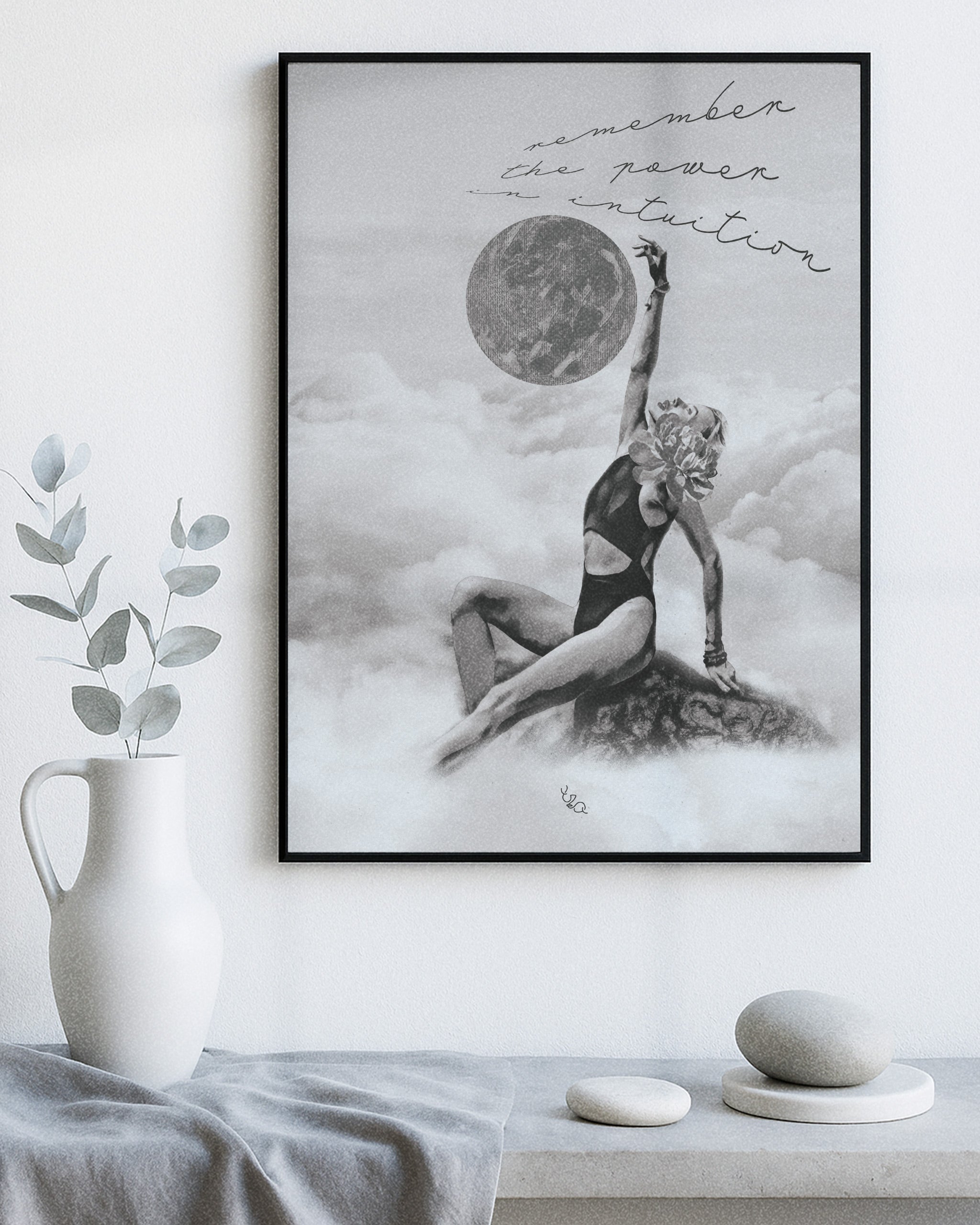 Framed women wall art for bedroom of a woman in a swimsuit with a moon above, on a white wall with decor items below.