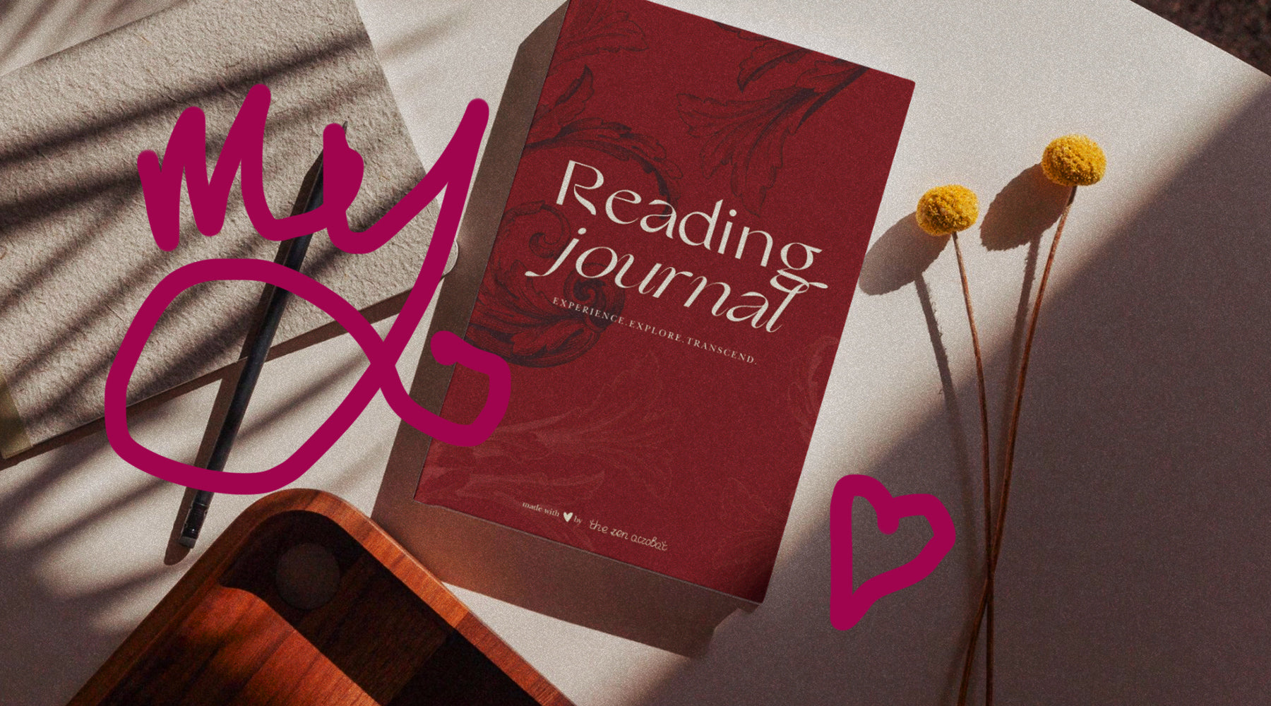 my book reading journal on a table with flowers and other objects, and a drawn heart next to it; 