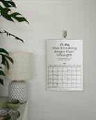 the minimalist self care calendar shown printed on a wall next to a plant and a lamp