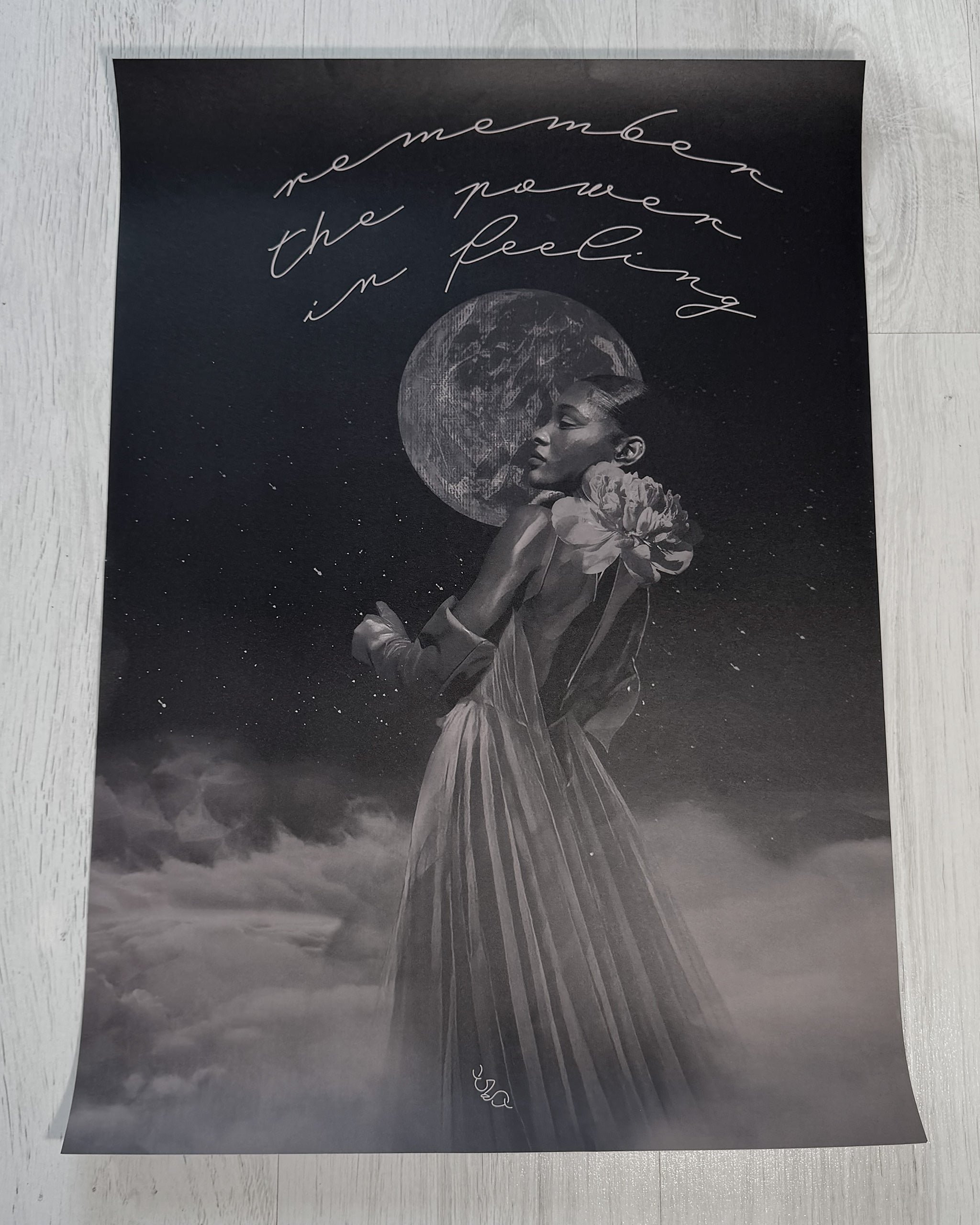 black white and grey wall art of a gentle empath -  a woman holding in front of the moon, surrounded by clouds and stars, with text 'remember the power in feeling' on a dark background.