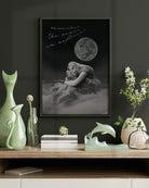 black white and grey wall art of a world changer framed in olive green frame over an olive wall over a brown wooden desk with decorations and flowers